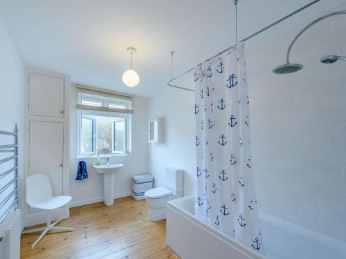 a bathroom with a toilet and a shower curtain at 4 Bed in Combe Martin 86108 in Combe Martin