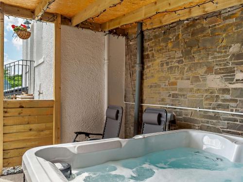a bath tub in a patio with two chairs at 2 Bed in Hawick 91905 in Roberton