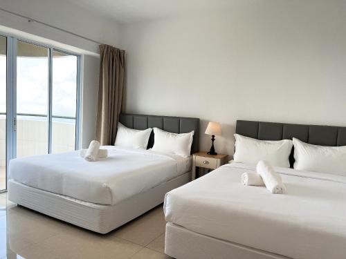 Una habitación de hotel con dos camas y una ventana. en Cloud Forest Homestay Genting Highlands, en Genting Highlands
