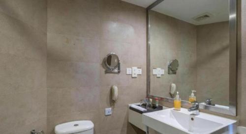 a bathroom with a sink and a toilet and a mirror at Ramada by Wyndham Wujiaochang Shanghai in Shanghai