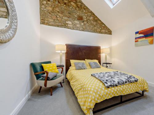 a bedroom with a bed and a chair and a mirror at 3 Bed in Tenby 94186 in Saint Florence