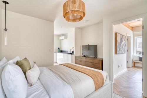 a white bedroom with a bed and a television at Stay Portland - Alberta Arts-tastic Mother-In-Law Suite in Portland