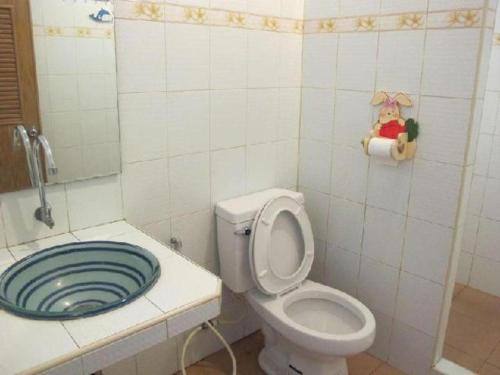 a bathroom with a white toilet and a blue sink at Baan Suan Phidchamika in Ban Wat Bot