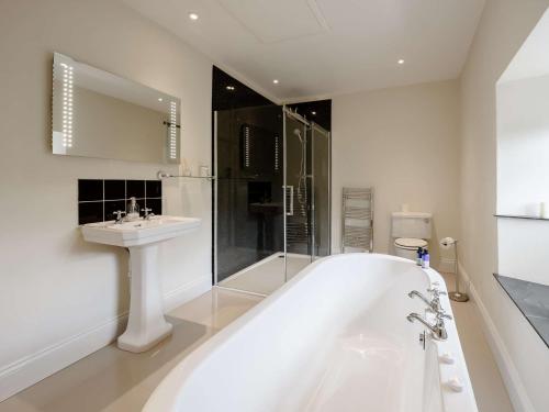 Un baño blanco con bañera y lavabo. en 1 Bed in Bideford 51784, en Parkham