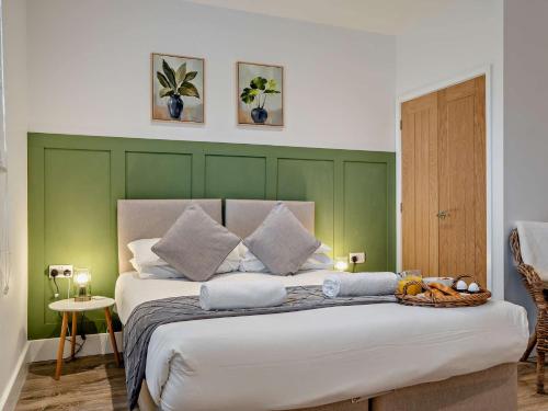 a bedroom with a large bed with green walls at 1 Bed in Newport 95453 in Newport