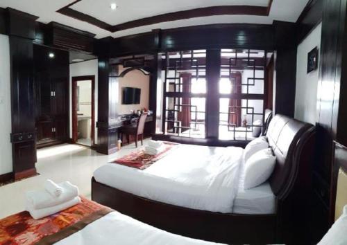 a large bedroom with a large bed and a desk at Favanhmai Hotel in Phonsavan