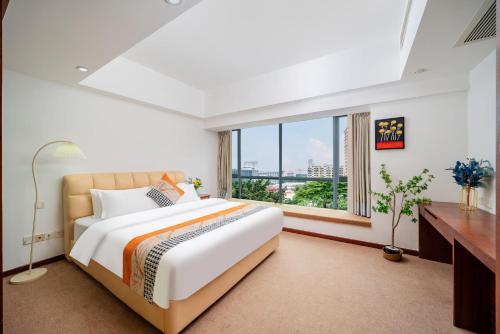 a bedroom with a large bed and a large window at Shengmei Ya International Service Apartment Guangzhou (Pazhou Convention and Exhibition Center Modiesha Metro Station Branch) in Guangzhou