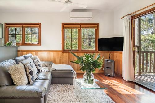 a living room with a couch and a tv at Beautiful 2BR Tranquil Rainforest Retreat Escape Free Wifi in Springbrook