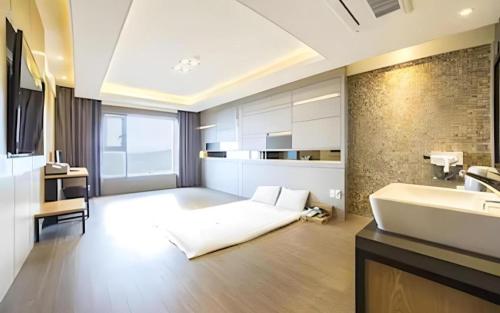 a large bathroom with a white bed and a sink at Pohang Hotel View in Pohang
