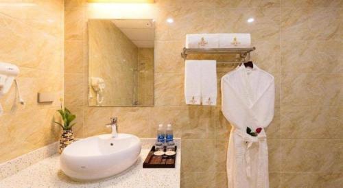 a bathroom with a sink and a white robe at Kim Bao Hotel in Hải Dương