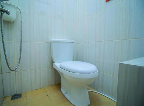 a bathroom with a white toilet and a shower at OYO 1596 Taman Homestay Syariah in Dumai