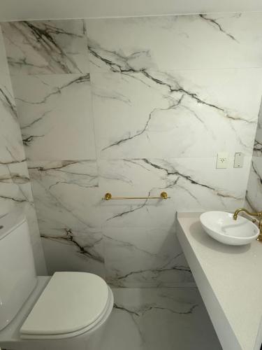 コモドーロ・リバダビアにあるCasa Éliteのトイレと洗面台を備えた白いバスルーム