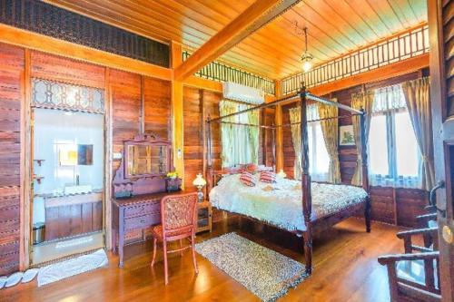 ein Schlafzimmer mit einem Bett und einem Schreibtisch in einem Zimmer in der Unterkunft Burann Bangtanode in Ban Bang Tanot