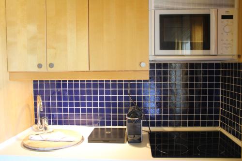 een keuken met blauwe tegels op de muur en een wastafel bij Sitges Beach Loft in Sitges