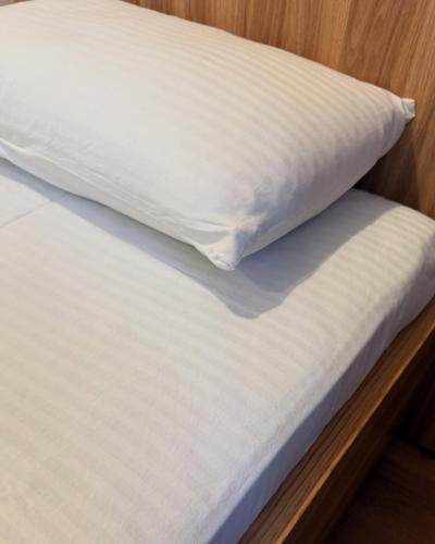 a bed with a white mattress and a pillow at Satti in Shymkent