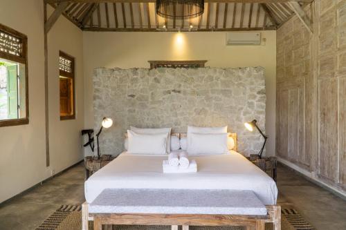 a bedroom with a large white bed in a room at Villa With Stunning Paddy Field Views - Kasongan Yogyakarta in Jarakan