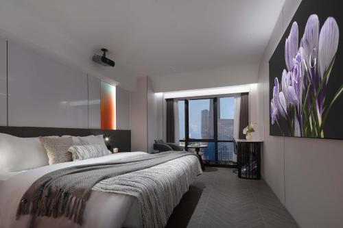 ein Schlafzimmer mit einem großen Bett und einem großen Fenster in der Unterkunft Chongqing Jiangbei Guanyinqiao Pedestrian Street Berry Hotel in Chongqing