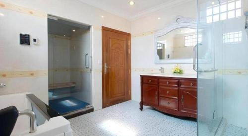 a bathroom with a glass shower and a sink at Jun Yue Hotel in Phnom Penh
