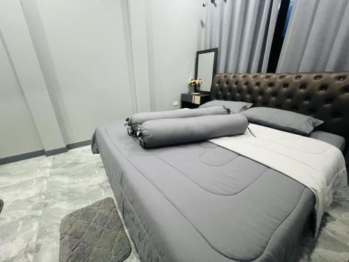 a bedroom with a large bed with a leather headboard at SRE- Holiday Home in Prime Village, Mae Sot 