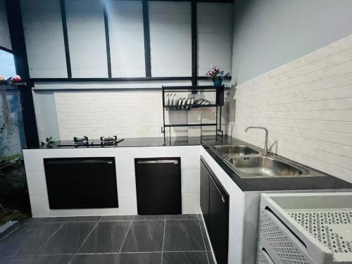 a kitchen with a sink and a counter top at SRE- Holiday Home in Prime Village, Mae Sot 