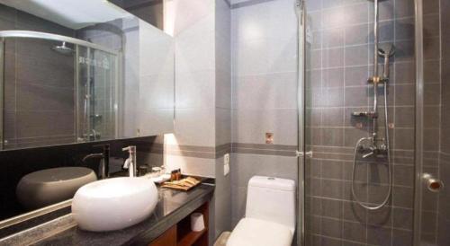 a bathroom with a shower and a toilet and a sink at James Joyce Coffetel Xian Dayanta Metro Station Branch in Xi'an