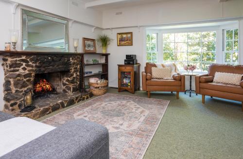 - un salon avec une cheminée et 2 chaises dans l'établissement Cartref, Vintage Welsh Charm Meets Modern Comfort, à Mont Dandenong