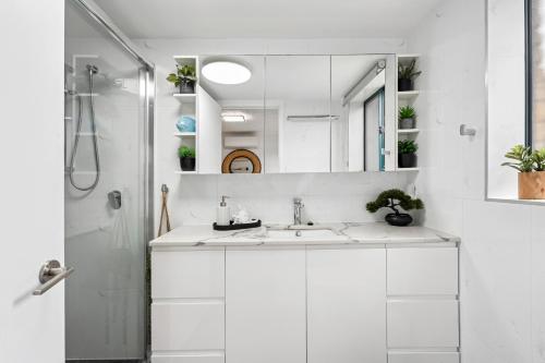 Palm Beach Paradiso في غولد كوست: حمام أبيض مع حوض ودش