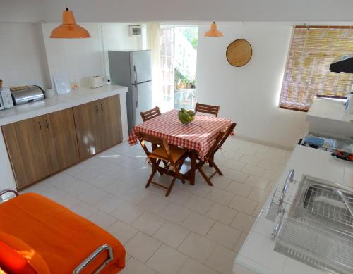 a kitchen with a table and chairs in a kitchen at Blue Appartment in La Gaulette