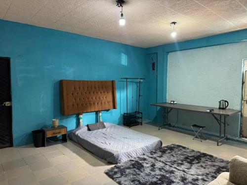 a blue room with a bed and a desk at Loft en Puebla in El Gallinero