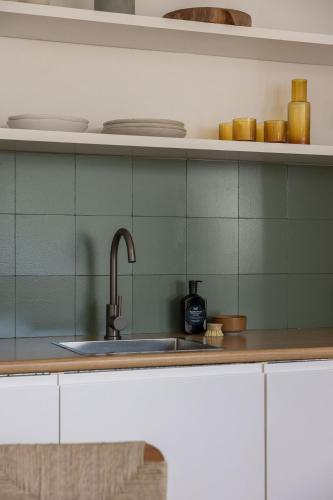 a kitchen with a sink and green tiles at The Local Studio - Luxury over 2 levels in Byron Bay