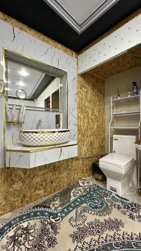 a bathroom with a sink and a toilet and a mirror at Hotel Ravshanbek in Samarkand