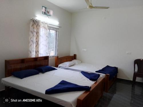 two twin beds in a room with a window at Coasta Homestay in Kāsarkod