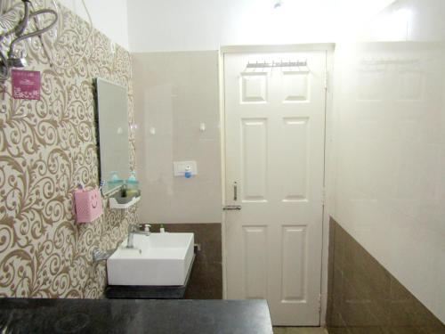a bathroom with a white sink and a mirror at Serenity Homes Near Rushikonda in Visakhapatnam