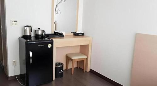 a kitchen with a desk with a refrigerator and a chair at Pyeongchang the white view in Pyeongchang 