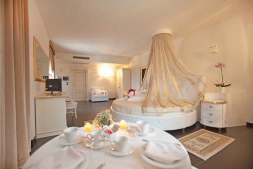 una camera da letto con un grande letto bianco con un tavolo con piatti di Tenuta Ippocrate a Montefredane