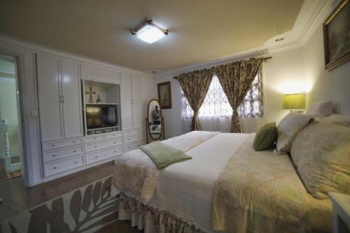 een slaapkamer met een groot bed en een televisie bij casa de ensueño in Cuenca