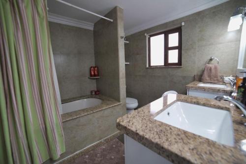 een badkamer met een wastafel, een bad en een douche bij casa de ensueño in Cuenca