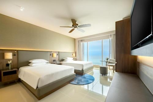 a bedroom with two beds and a flat screen tv at Hyatt Regency Cartagena in Cartagena de Indias