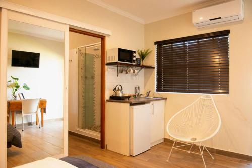 cocina con fregadero y silla en una habitación en MacLeod House, en Bloemfontein