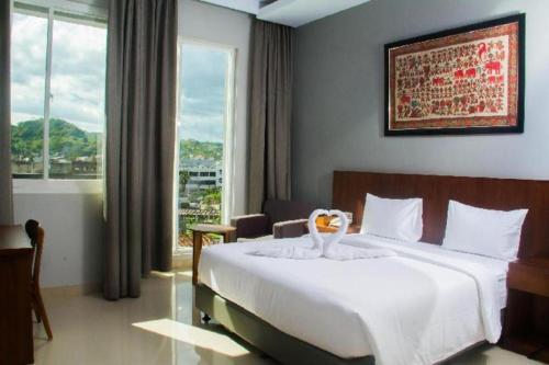 a bedroom with a large bed and a large window at HOTEL GRAND KUTILANG SYARIAH in Lampung