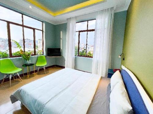 a bedroom with a large bed and two windows at Seventeen Hotel in Vung Tau