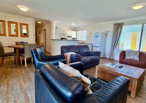 a living room with a couch and a table at Sandcastles At The Beach Outstanding Location! in Perth