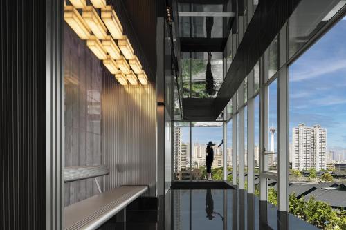 a person standing in a building looking out the window at ISEYA Serviced Apart-ment Chengdu Taikoo Li Flagship in Chengdu