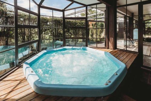 a jacuzzi tub on a deck with windows at Family Fun - 4BR home with swimming pool and spa in New Plymouth