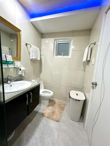 a white bathroom with a sink and a toilet at Deluxe room with king bed and Balcony at Kandi Palace in Angeles
