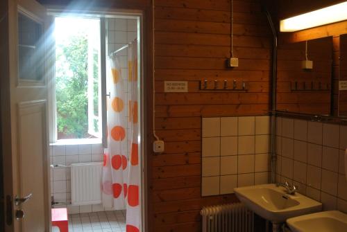 a bathroom with a sink and a mirror and a window at Porvoo Hostel in Porvoo