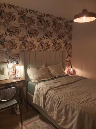 a bedroom with a bed and a desk with a lamp at Chambre sérénité Montreuil in Montreuil
