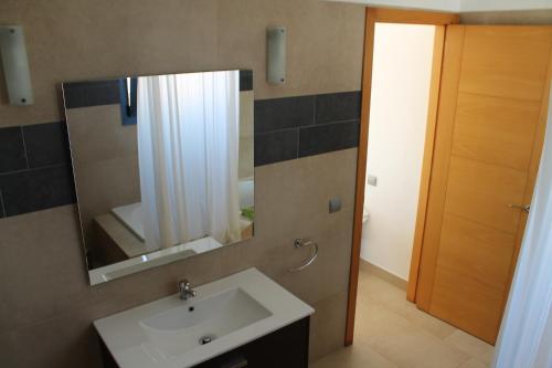 y baño con lavabo y espejo. en Villa Romaní Apartament, en Ciutadella