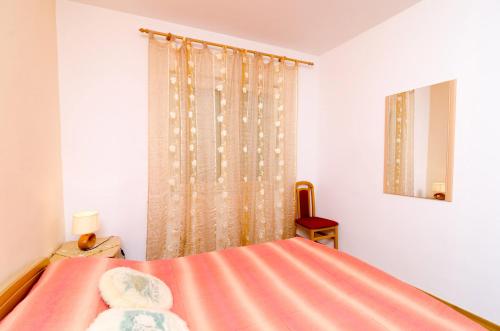 a bedroom with a bed with a pink sheet at Apartment STJEPKO in Cavtat