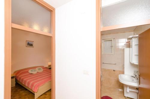 a small bathroom with a bed and a sink at Apartment STJEPKO in Cavtat